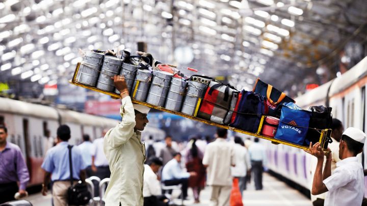 dabbawala mengangkat dabbas ke dalam kereta api