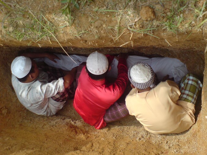 menurunkan jenazah ke liang lahad