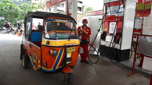 pekerja mengisi minyak di pam